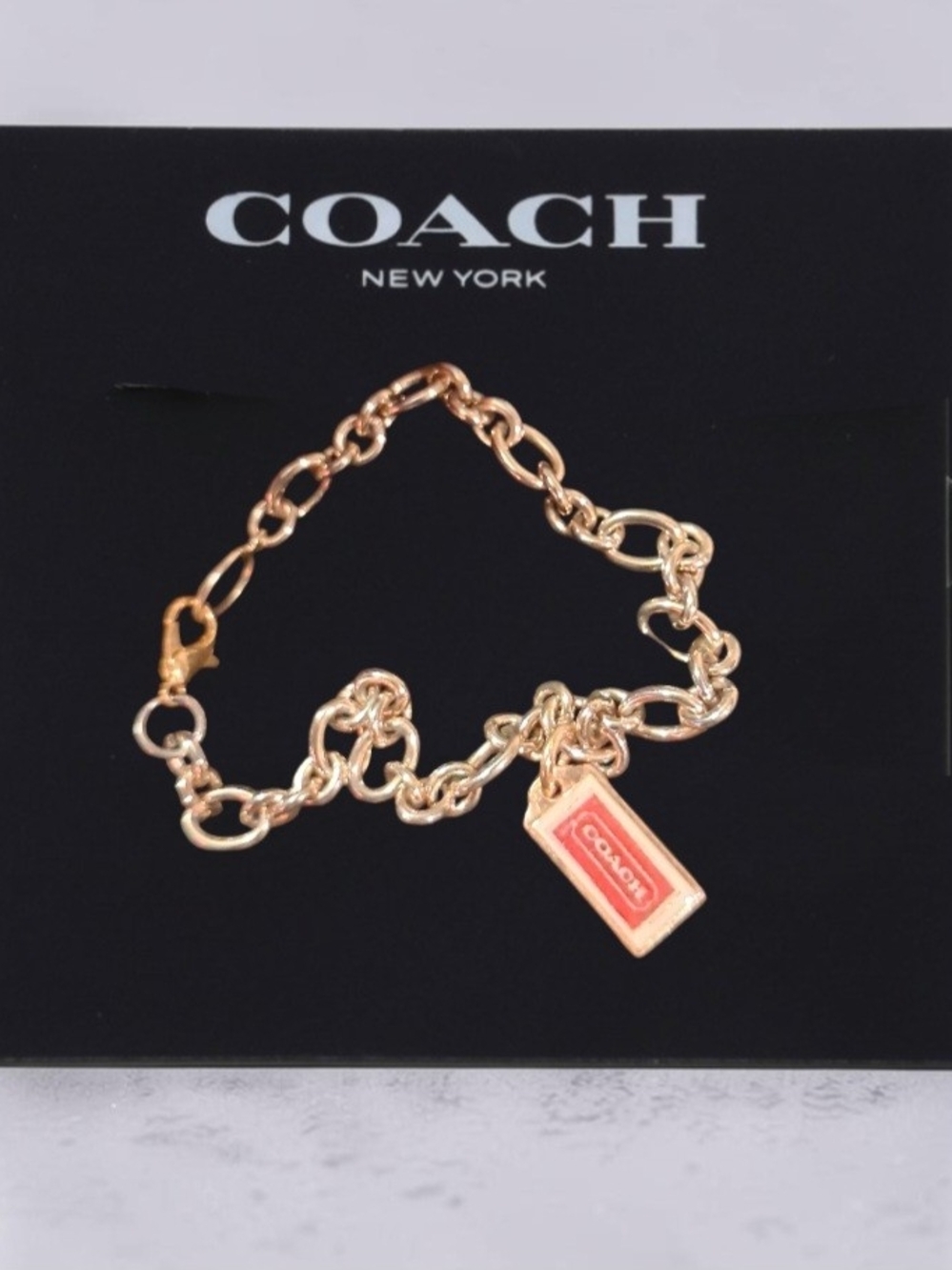 Coach Gold-Tone Chain Bracelet with Pink Enamel Tag